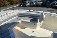 2019 Cobia 262 Center Console boat with cushioned seating in a marina setting.