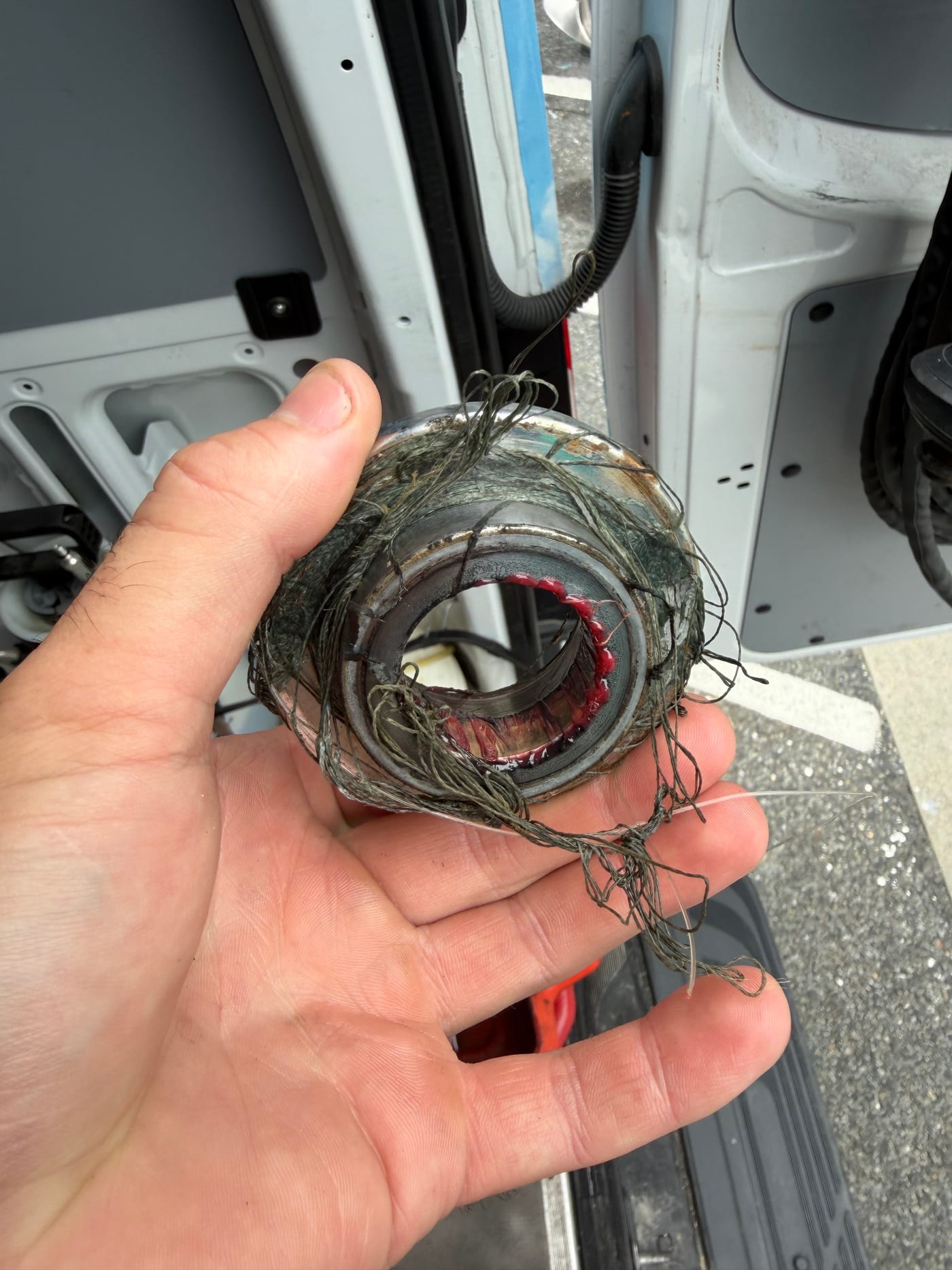 A propeller hub off a Yamaha, held in a hand, with fishing line wound tightly through it