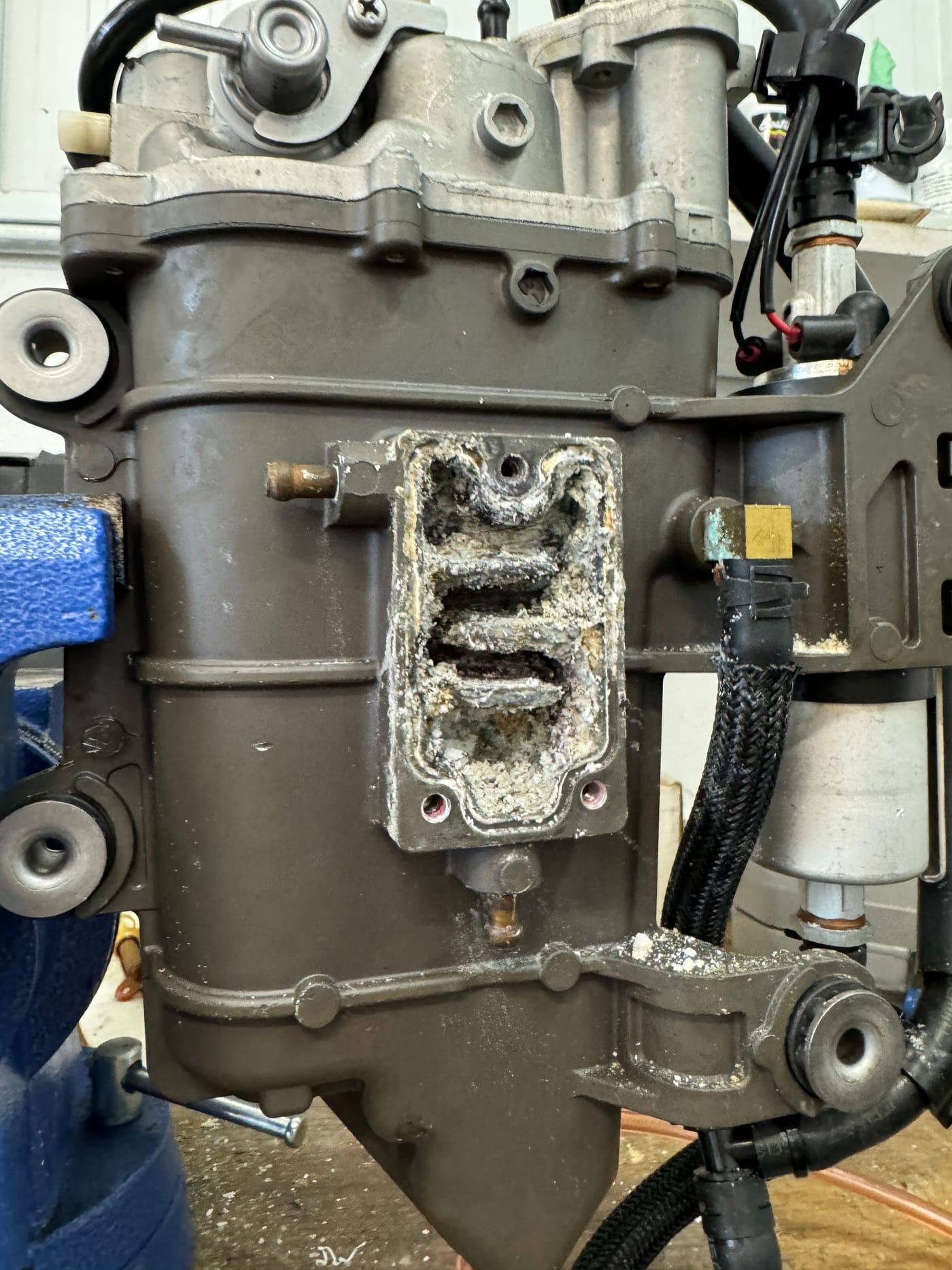 A fuel cooler off the back of a Yamaha vapor separator tank with its cooling passage packed solid with white corrosion