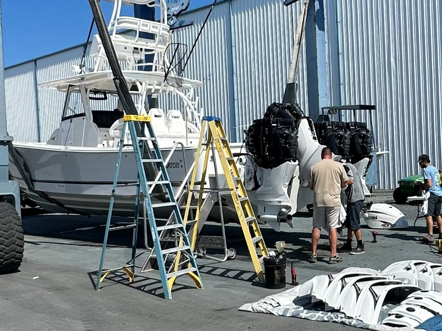 RT 113 technicians working on quad Yamaha outboards, cowlings off and laid out on the tarp