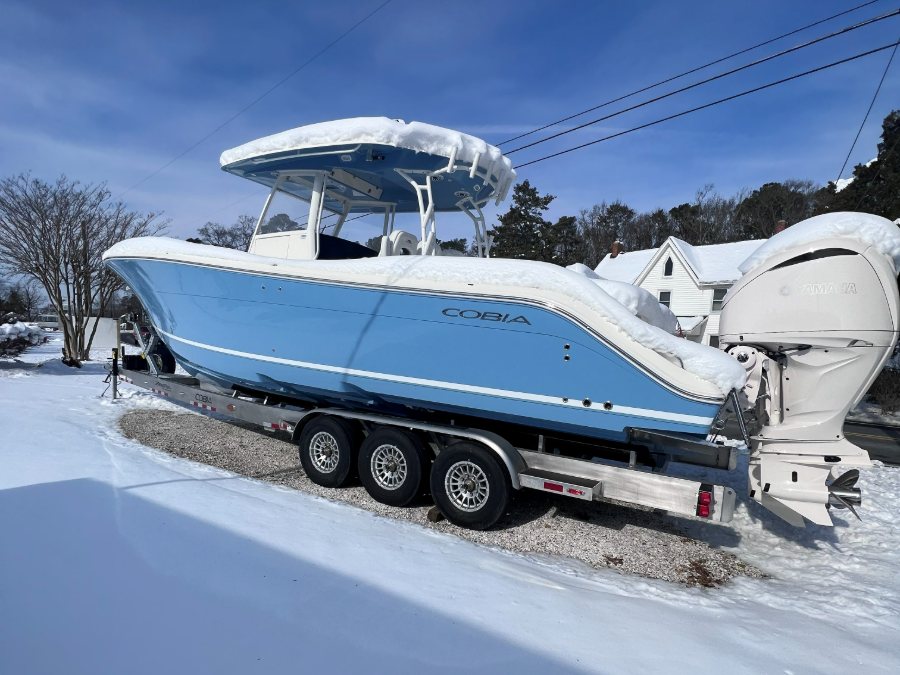 A Cobia center console under snow on its trailer in the RT 113 yard